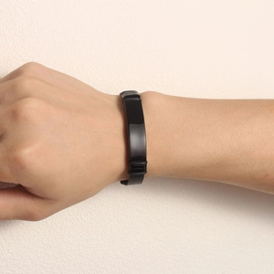 Detail shot of a black stainless steel Milanese mesh bracelet with a polished ID bar