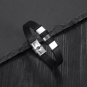 Detail of men's leather and stainless steel bracelet with engraved fold-over clasp