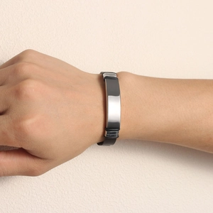 Detail of adjustable black mesh bracelet with a polished silver curved plate for men