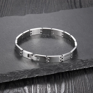 Detailed macro view of silver geometric stainless steel bracelet with brushed metal finish