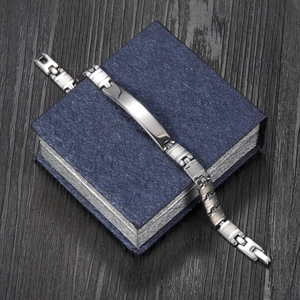 Polished stainless steel ID bracelet with H-link chain on dark blue jewelry box