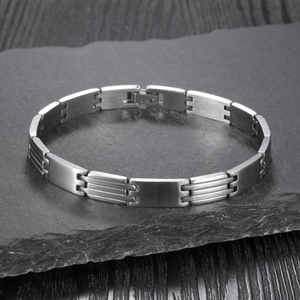 Minimalist silver stainless steel geometric link bracelet displayed on dark slate stone