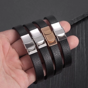 Detail of four black PU leather bracelets with polished silver and rose gold metal clasps