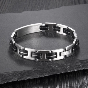 Dettaglio macro del bracciale punk da uomo in acciaio inossidabile con silicone nero e maglie H