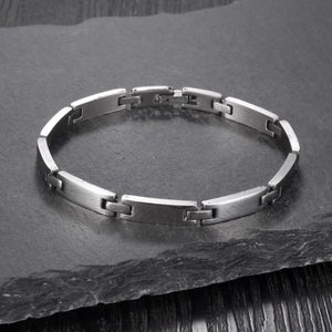 Sleek matte stainless steel link bracelet on rock surface in a 45-degree angle view