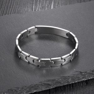 Macro detail of silver stainless steel curb chain bracelet with matte rectangular metal plate