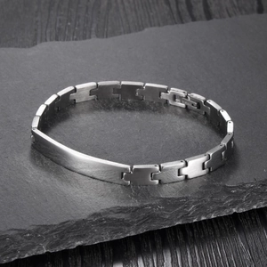 Minimalist stainless steel bar link bracelet displayed on dark natural stone background