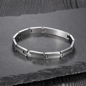 Detailed close-up of matte silver stainless steel link bracelet on dark slate background