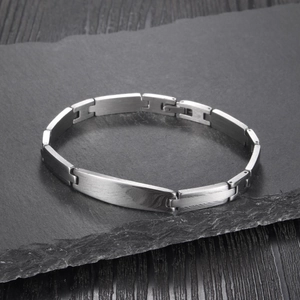 Minimalist silver steel chain bracelet for men with a polished metal plate on rock surface