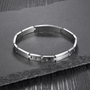 Close-up of silver steel link bracelet with brushed and polished finish on stone surface