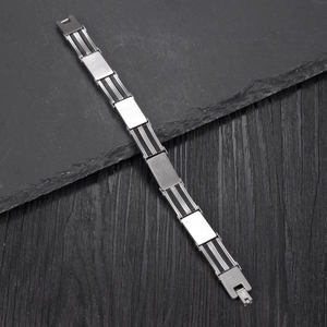 Mens stainless steel silicone bracelet with curved metal plate on rock background