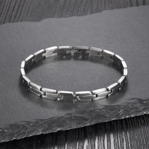 Close-up of matte silver stainless steel bracelet links with ST. STEEL engraving