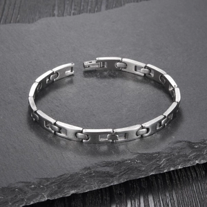 Minimalist stainless steel chain bracelet with silver brushed texture on stone surface