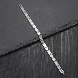 Minimalist stainless steel link chain bracelet for women on a natural slate stone background