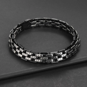 Macro shot of titanium steel men's bracelet with three-row link design and X engravings