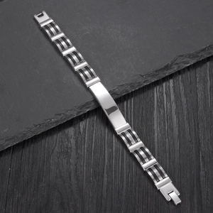 Men's stainless steel silicone bracelet with polished metal plate on dark rock background