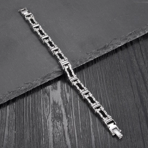 Industrial style men's stainless steel motorcycle chain bracelet on a dark stone surface