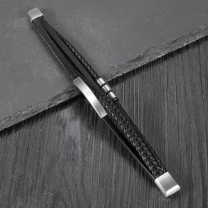 Multilayer black woven leather bracelet with stainless steel beads on dark background