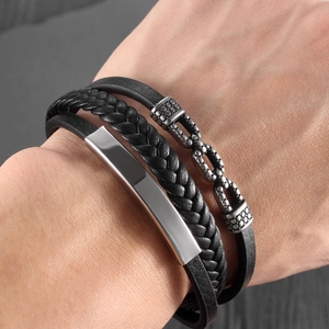 Close-up of men's multilayered black leather bracelet with a polished silver metal plate