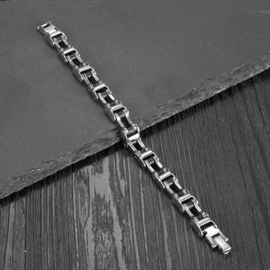 Industrial punk stainless steel biker chain bracelet displayed on dark textured background