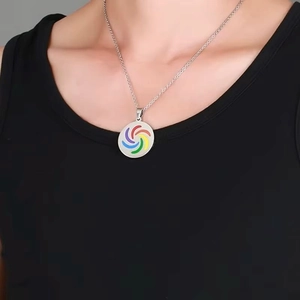 Gros plan d'un pendentif en acier inoxydable avec spirale arc-en-ciel porté par un mannequin