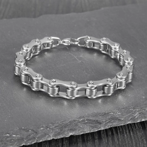 Men's stainless steel bicycle chain bracelet on dark stone background with lobster clasp