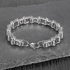 Detail of silver stainless steel motorcycle chain bracelet on a black rock base