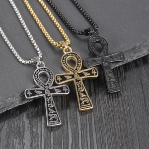 Détail de pendentifs croix Ankh en or, argent et noir avec gravures égyptiennes