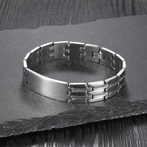 Bracciale da uomo in acciaio inossidabile spazzolato con piastra liscia su legno scuro