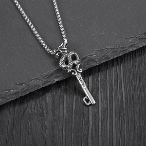 Chinese dragon key pendant necklace in titanium steel on a black textured background