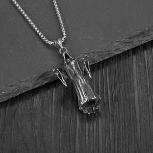 Gothic punk grim reaper ghost pendant in vintage steel on a rustic stone background