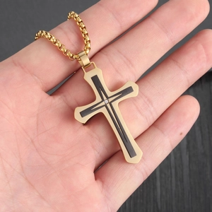 Macro shot of gold stainless steel hip hop cross pendant with black inlay and zircon gem