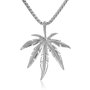 Vue détaillée du pendentif feuille argenté avec veines ciselées et chaîne à mailles