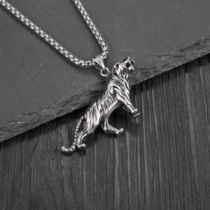 Collier avec pendentif tigre en acier titane argenté sur fond texturé sombre