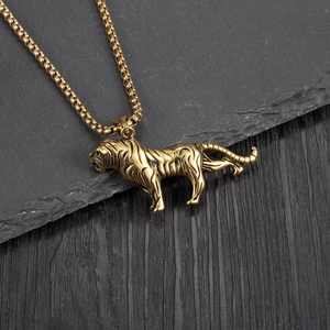 Détail macro d'un pendentif tigre en titane doré avec rayures noires sur fond de pierre