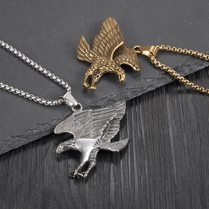 Eagle pendant necklace in silver and gold finish with detailed wings on stone background