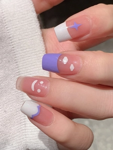 Détail de stickers à ongles brillants violets et blancs avec motifs étoiles, nuages et sourires