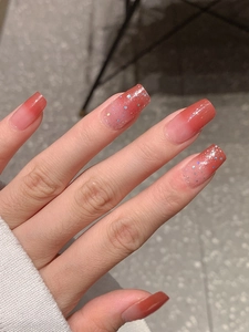 Vue détaillée de faux ongles longs carrés dégradés rouges avec finition pailletée brillante