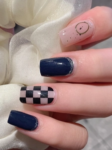 Detail of dark blue and pink checkered nail stickers with silver glitter on square nails