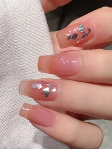 Detailed shot of gradient pink coffin press-on nails with silver foil and glitter accents