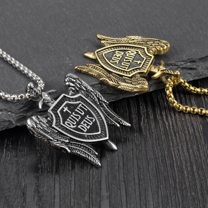 Macro detail of retro steel shield pendant with angel wings and Quis Ut Deus engraving