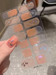 Macro detail of nude gradient nail wraps with iridescent glitter and foil flakes