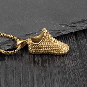 Gros plan détaillé d'un pendentif basket doré avec texture en maille et finition brillante