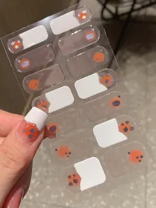 Detail of sweet French white blush nail stickers with orange and purple glitter accents