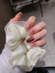 Detail of glitter brown and pink gradient nail stickers with a white organza scrunchie