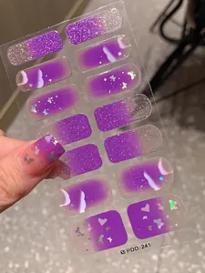 Detail of purple gradient nail stickers with silver glitter and butterfly sequins