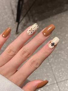 Close-up of caramel and cream floral plaid pattern on long rectangular nail wraps