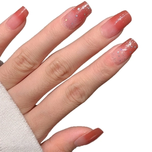 Faux ongles French dégradé rose avec paillettes scintillantes sur fond blanc immaculé