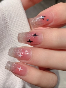 Macro detail of pink gradient long square nails with silver glitter and star patterns