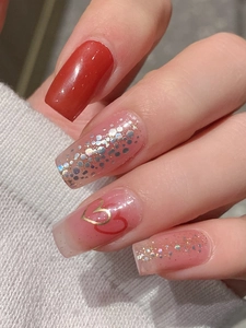 Détail d'autocollants pour ongles cœur rouge gelée avec paillettes argentées sur ongles longs